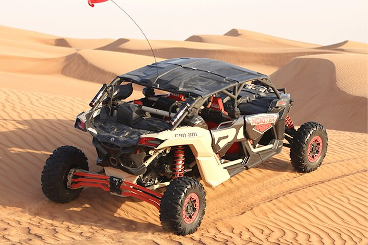 Red Can-Am Maverick Turbo dune buggy racing on desert sand