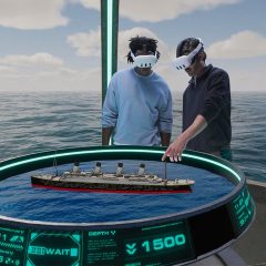 Guests using VR controls to examine a 3D model of the Titanic ship